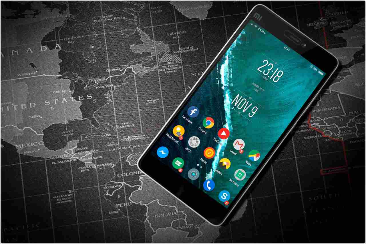 Close-up of an Android smartphone placed on a detailed world map background.